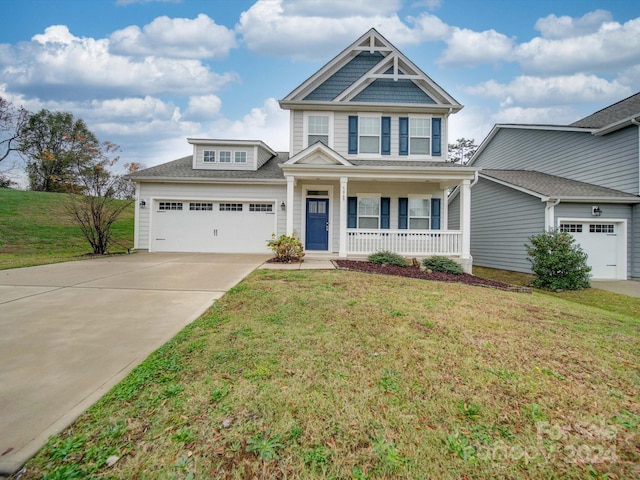 craftsman house featuring a front yard, a porch, and a garage