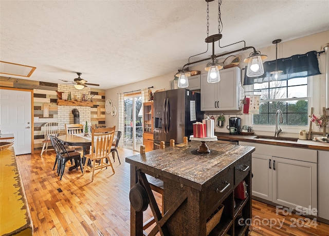 kitchen featuring gray cabinetry, plenty of natural light, stainless steel refrigerator with ice dispenser, and light wood-type flooring