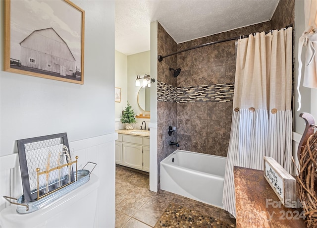 bathroom featuring tile patterned floors, vanity, shower / bathtub combination with curtain, and a textured ceiling