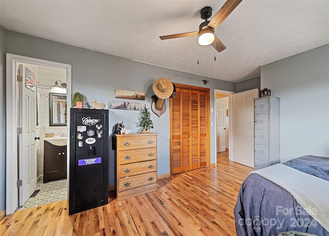 bedroom featuring a closet, connected bathroom, light hardwood / wood-style floors, and ceiling fan