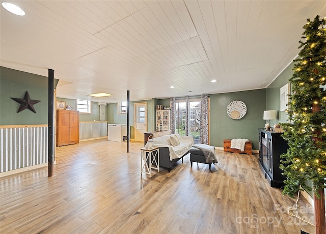 living room with a healthy amount of sunlight, light wood-type flooring, and wood ceiling