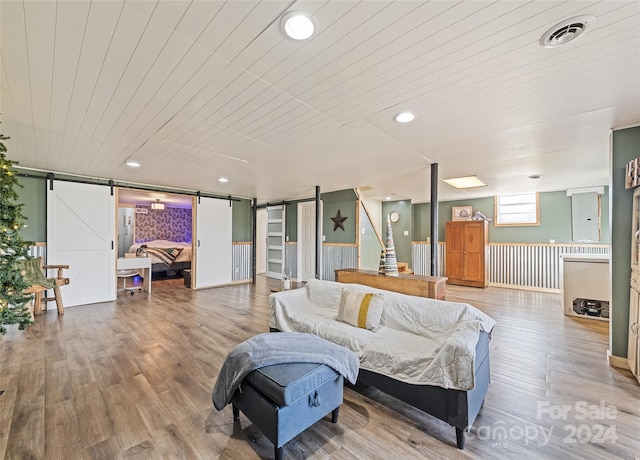 living room featuring a barn door, wooden ceiling, and wood-type flooring