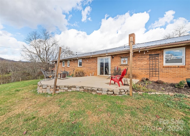 back of house with a yard and a patio