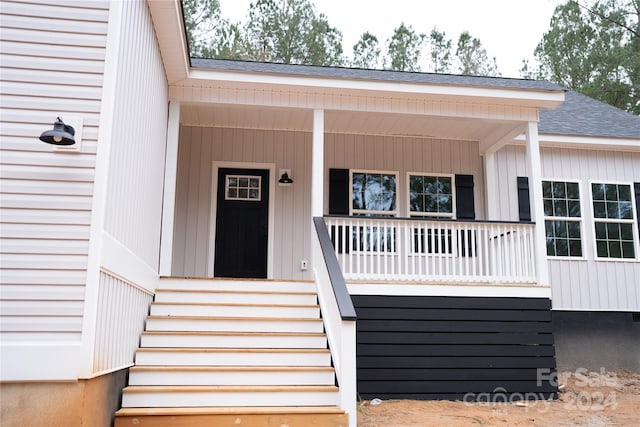 view of exterior entry featuring a porch