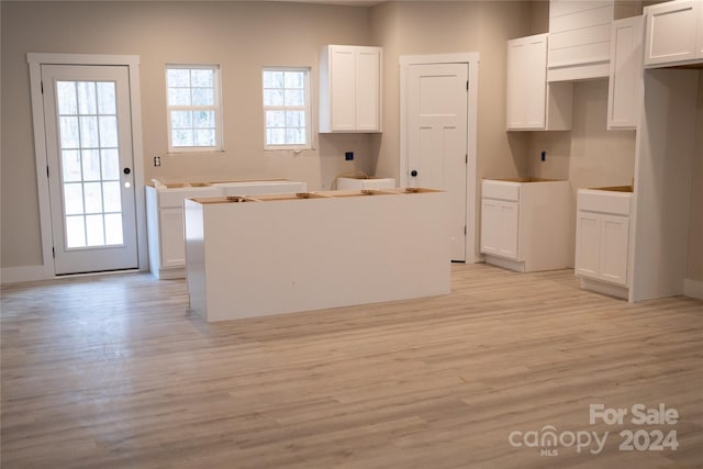 kitchen featuring a center island, light hardwood / wood-style floors, and white cabinetry