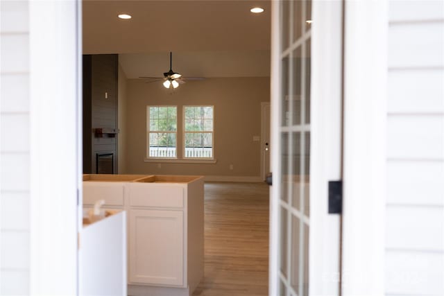 interior space featuring white cabinets, light wood-type flooring, and ceiling fan