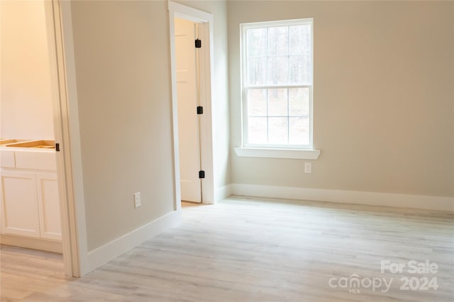 hall with light wood-type flooring and a wealth of natural light