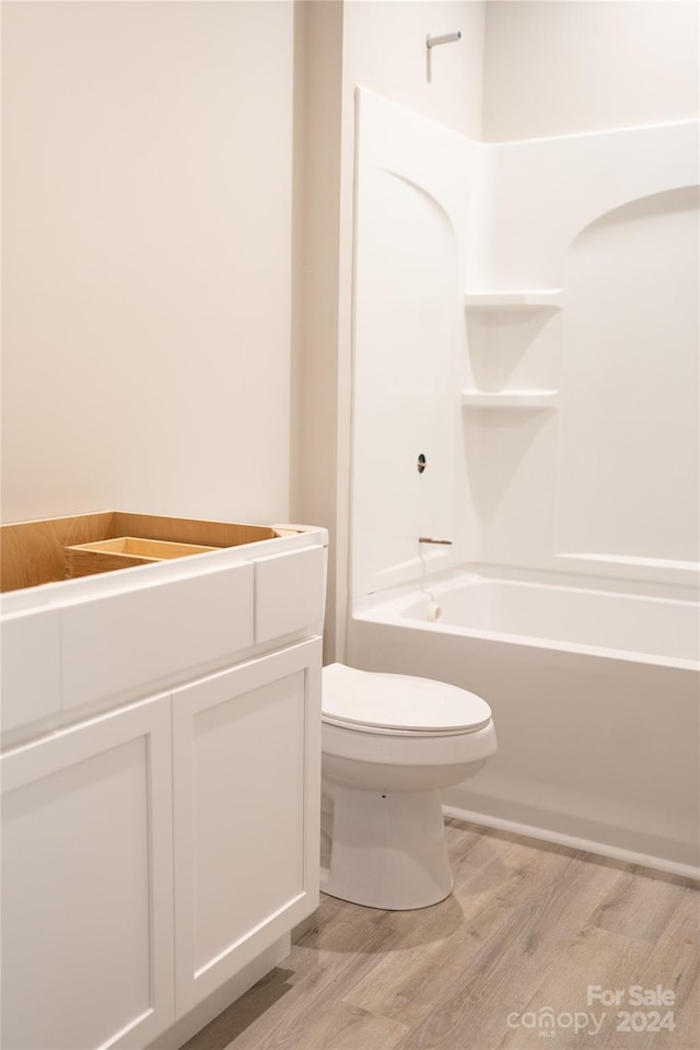 full bathroom with bathing tub / shower combination, hardwood / wood-style floors, vanity, and toilet