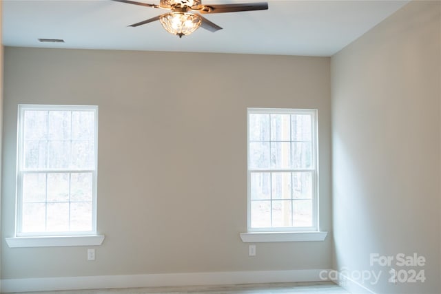 spare room with hardwood / wood-style flooring, ceiling fan, and a healthy amount of sunlight