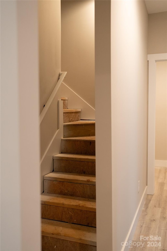 stairway featuring wood-type flooring