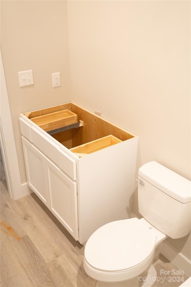 bathroom with hardwood / wood-style flooring and toilet