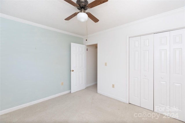 unfurnished bedroom with light carpet, a closet, ceiling fan, and crown molding