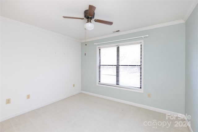 empty room featuring ceiling fan, light colored carpet, and ornamental molding