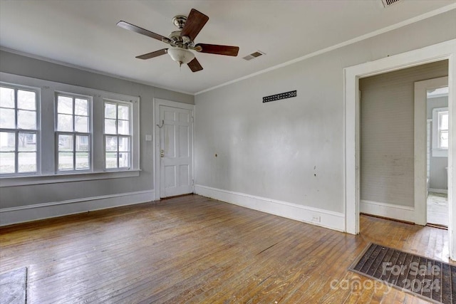 empty room featuring hardwood / wood-style flooring, ceiling fan, and ornamental molding