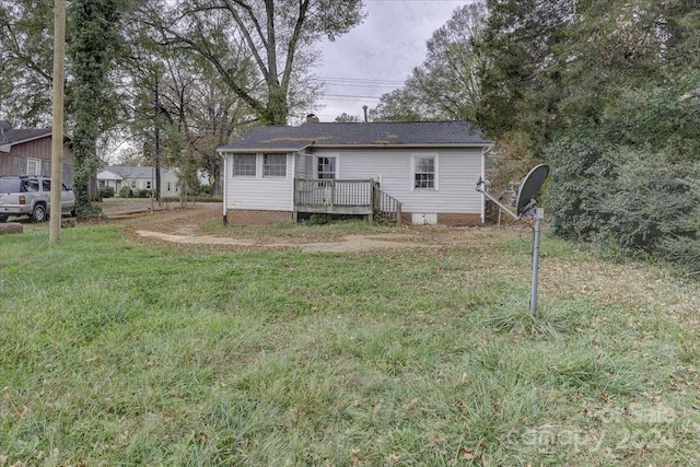 rear view of house featuring a yard and a wooden deck