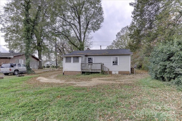 rear view of property with a yard and a wooden deck