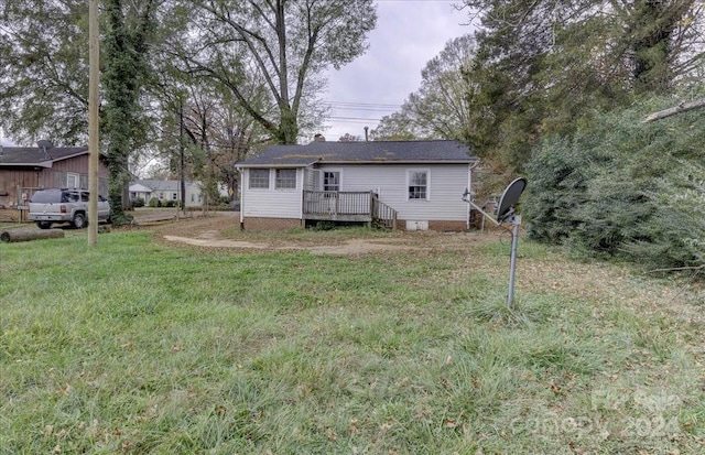 back of property with a yard and a wooden deck