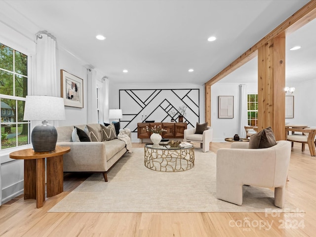 living room with a notable chandelier, a healthy amount of sunlight, and light hardwood / wood-style flooring