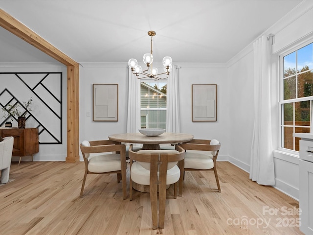 dining area featuring crown molding, light hardwood / wood-style flooring, and a chandelier