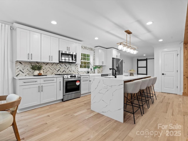 kitchen with white cabinetry, pendant lighting, and appliances with stainless steel finishes