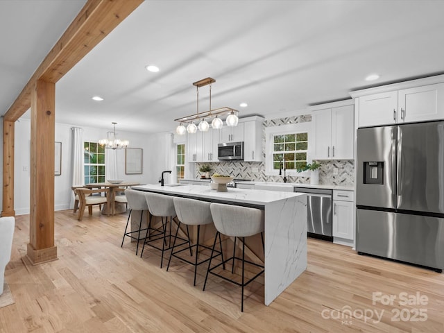 kitchen featuring white cabinetry, stainless steel appliances, and a center island