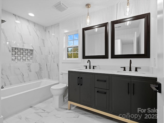 full bathroom featuring tiled shower / bath, vanity, and toilet