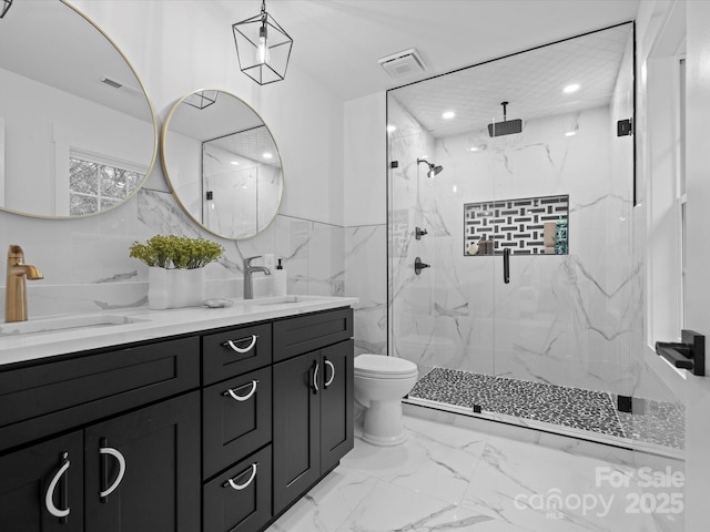 bathroom featuring vanity, toilet, an enclosed shower, and tile walls