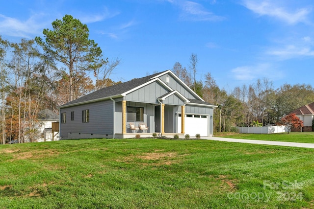 view of front of house featuring a garage, covered porch, and a front yard