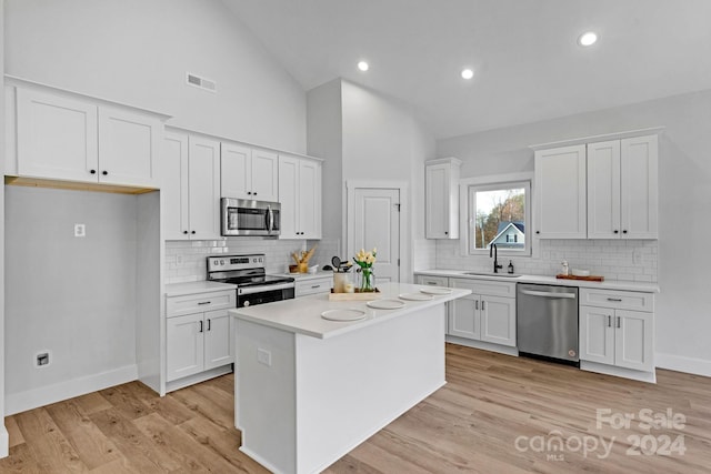 kitchen featuring appliances with stainless steel finishes, light hardwood / wood-style flooring, and white cabinetry