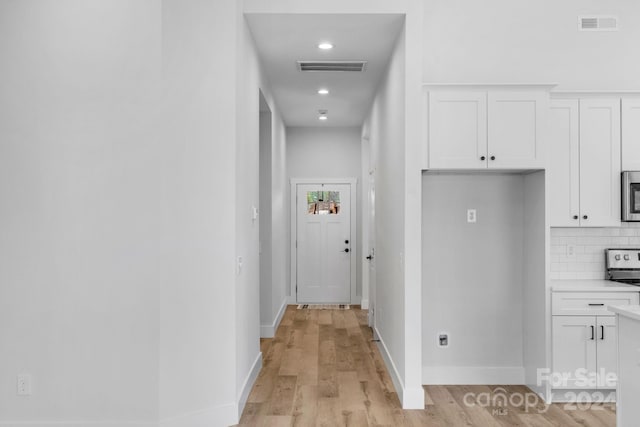 hallway with light hardwood / wood-style floors