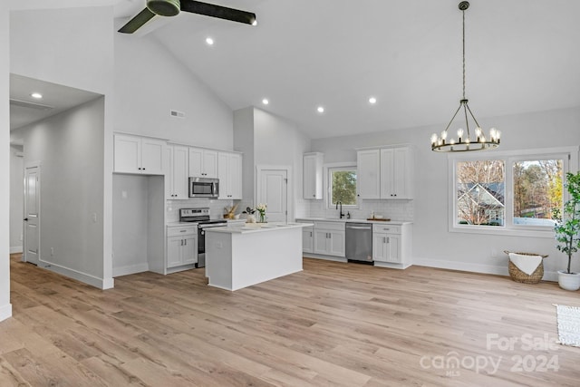 kitchen featuring white cabinets, a kitchen island, appliances with stainless steel finishes, and light hardwood / wood-style flooring