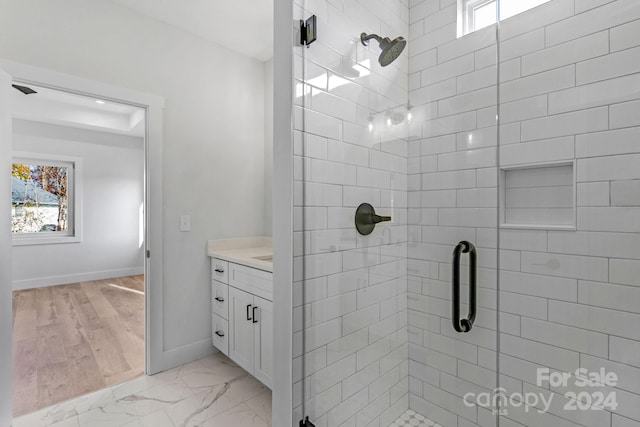 bathroom with plenty of natural light, vanity, an enclosed shower, and hardwood / wood-style flooring