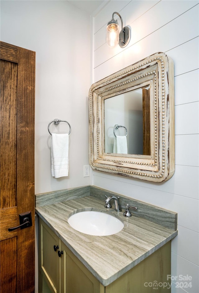 bathroom with vanity and tile walls