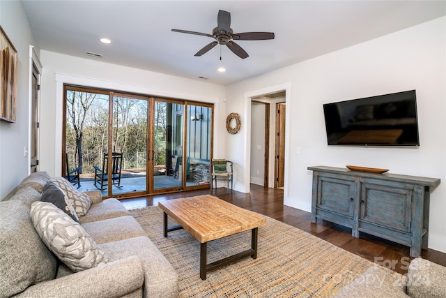 living room featuring ceiling fan and dark hardwood / wood-style floors