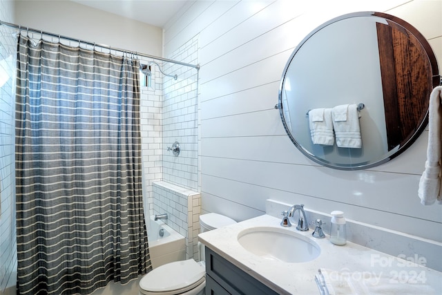 full bathroom featuring shower / bath combo, vanity, toilet, and wooden walls