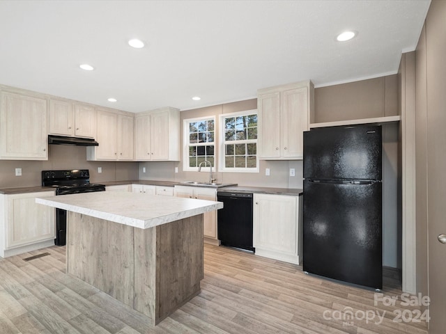 kitchen featuring black appliances, a center island, sink, and light hardwood / wood-style flooring