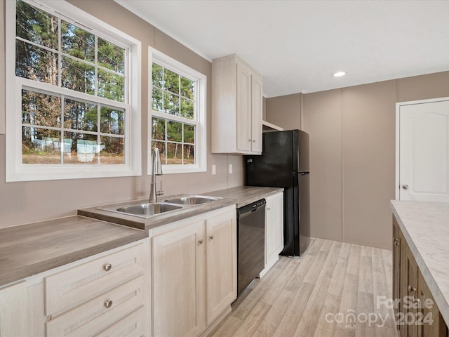 kitchen with light wood-type flooring, sink, a healthy amount of sunlight, and black appliances