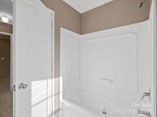 bathroom with hardwood / wood-style floors and bathing tub / shower combination