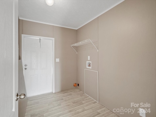 laundry area with a textured ceiling, light wood-type flooring, hookup for a washing machine, and crown molding