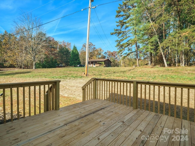 wooden deck featuring a lawn