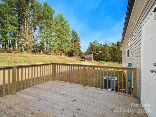 wooden terrace with a lawn and central air condition unit