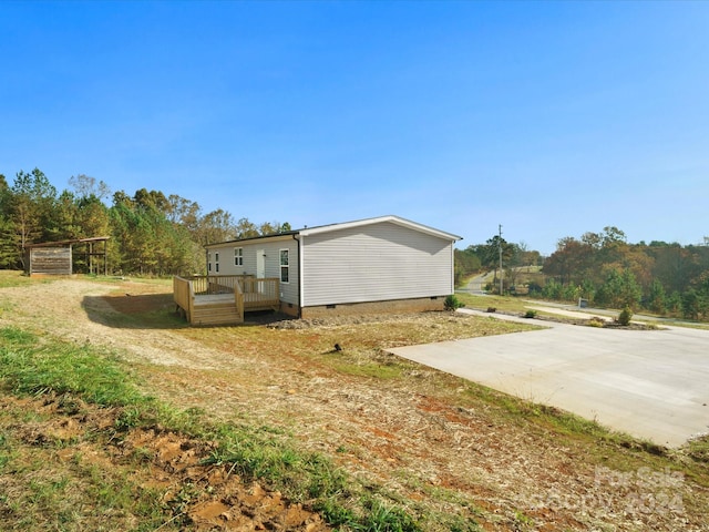 view of side of property featuring a deck and a patio