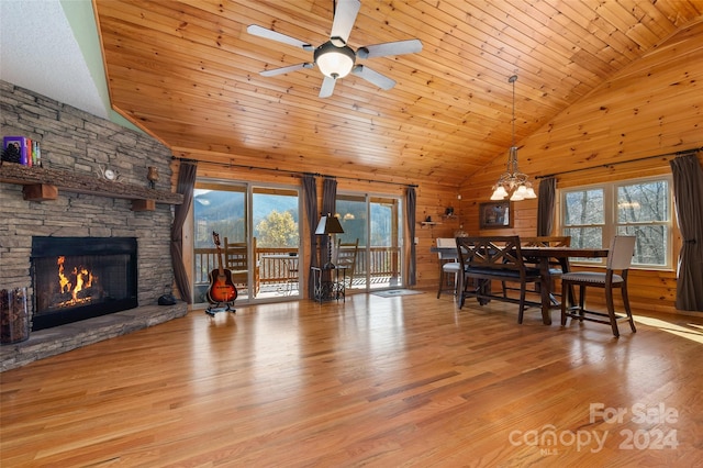 dining area featuring high vaulted ceiling, wooden walls, light wood-type flooring, a fireplace, and wood ceiling