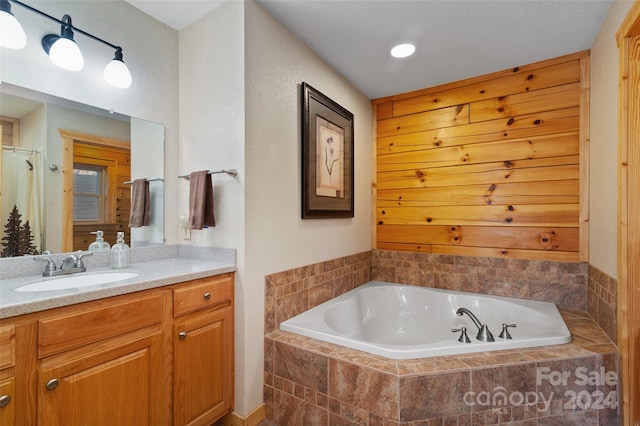 bathroom featuring vanity and tiled bath