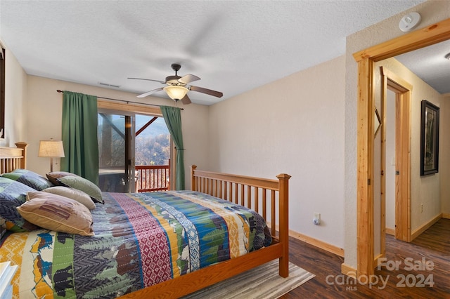 bedroom with access to exterior, a textured ceiling, dark hardwood / wood-style floors, and ceiling fan