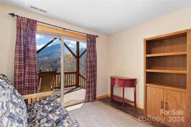 bedroom with a mountain view, hardwood / wood-style floors, and access to exterior