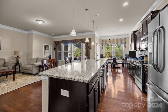 kitchen with appliances with stainless steel finishes, crown molding, dark wood-type flooring, decorative light fixtures, and an island with sink