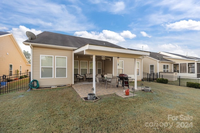 rear view of property with ceiling fan, a yard, and a patio