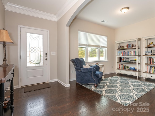 entrance foyer featuring dark wood-type flooring and ornamental molding