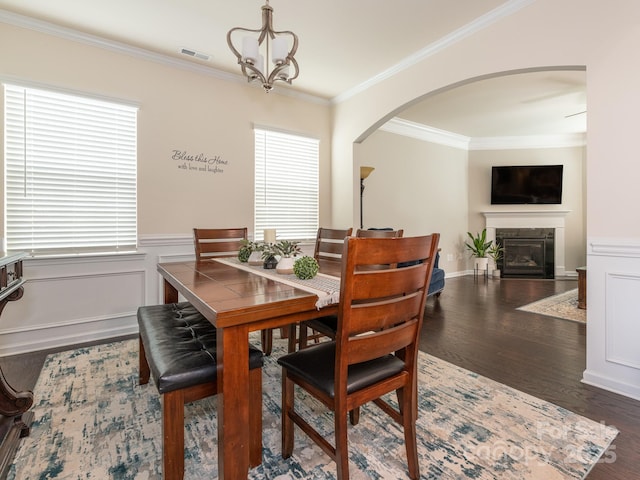 dining area featuring dark hardwood / wood-style flooring, an inviting chandelier, and ornamental molding